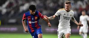 Lamine Yamal (Barcelona) a Toni Kroos (Real Madrid) v souboji o míč během finále Superpoháru