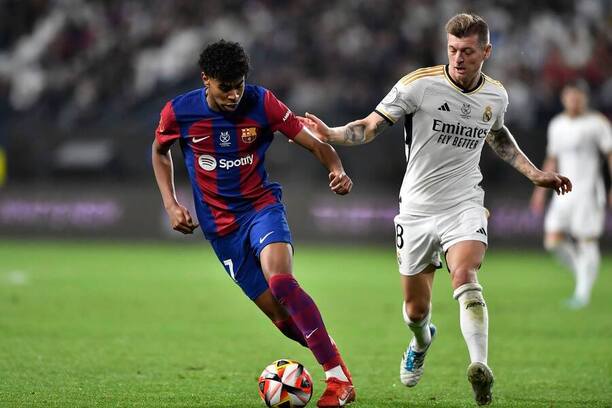 Lamine Yamal (Barcelona) a Toni Kroos (Real Madrid) v souboji o míč během finále Superpoháru