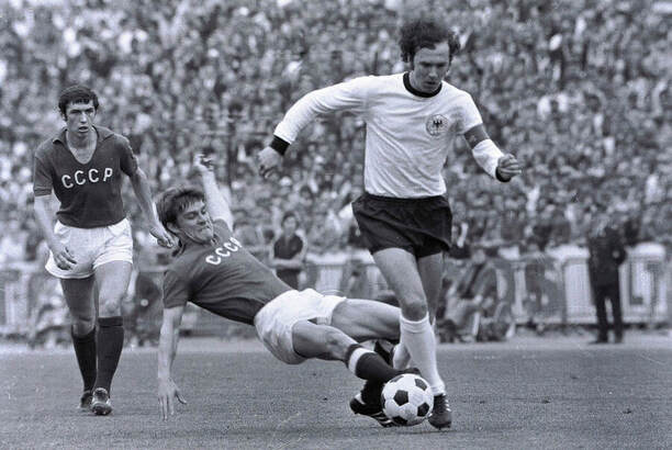Franz Beckenbauer v dresu Západního Německa je atakován hráčem SSSR