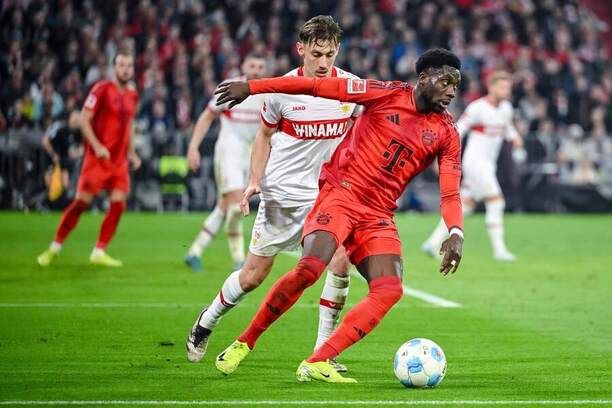Anthony Rouault ze Stuttgartu (v pozadí) se snaží obrat o míč Alphonsa Daviese, který hájí barvy Bayernu Mnichov