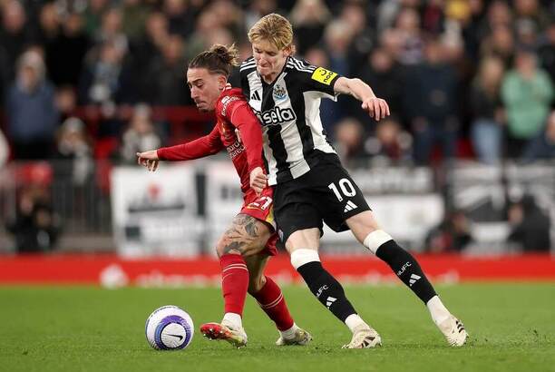 Liverpoolský hráč Kostas Tsimikas brání míč před Anthonym Gordonem z Newcastlu