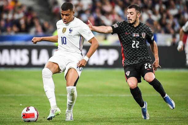 Hvězdný útočník Kylian Mbappé v držení míče. Vpravo chorvatský obránce Josip Juranovič