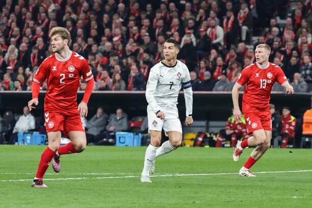 Cristiano Ronaldo v oblžení dvou dánských obránců