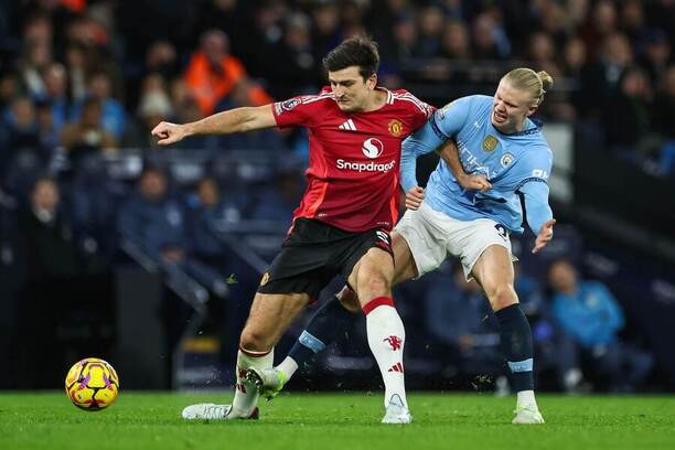 Harry Maguire (vlevo) a Erling Haaland v souboji o míč