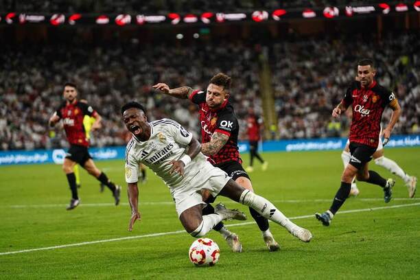 Španělský Superpohár 2025: Vinícius Jr. v dresu Realu Madrid během pádu po souboji o míč