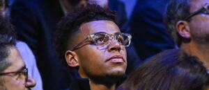 Désiré Doué se raduje ze zisku ocenění Golden Boy, na fotce v hledišti jako divák na tenisovém utkání v Paříži