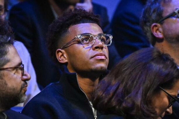 Désiré Doué se raduje ze zisku ocenění Golden Boy, na fotce v hledišti jako divák na tenisovém utkání v Paříži