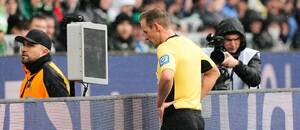 Německý sudí Sascha Stegemann zkoumá situaci pomocí videorozhodčího