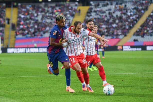 Hvězda Barcelony Lamine Yamal (vlevo) v&nbsp;souboji o&nbsp;míč s&nbsp;Daleym Blindem, obráncem Girony